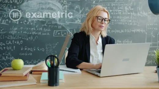 Professora concentrada planejando prova online em notebook em sala de aula, expressão tranquila e focada